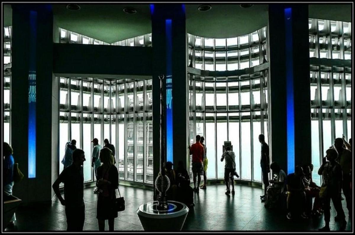 a group of people standing in a building with large windows