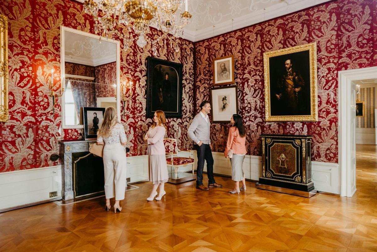 un gruppo di persone in piedi in un museo che guardano i dipinti