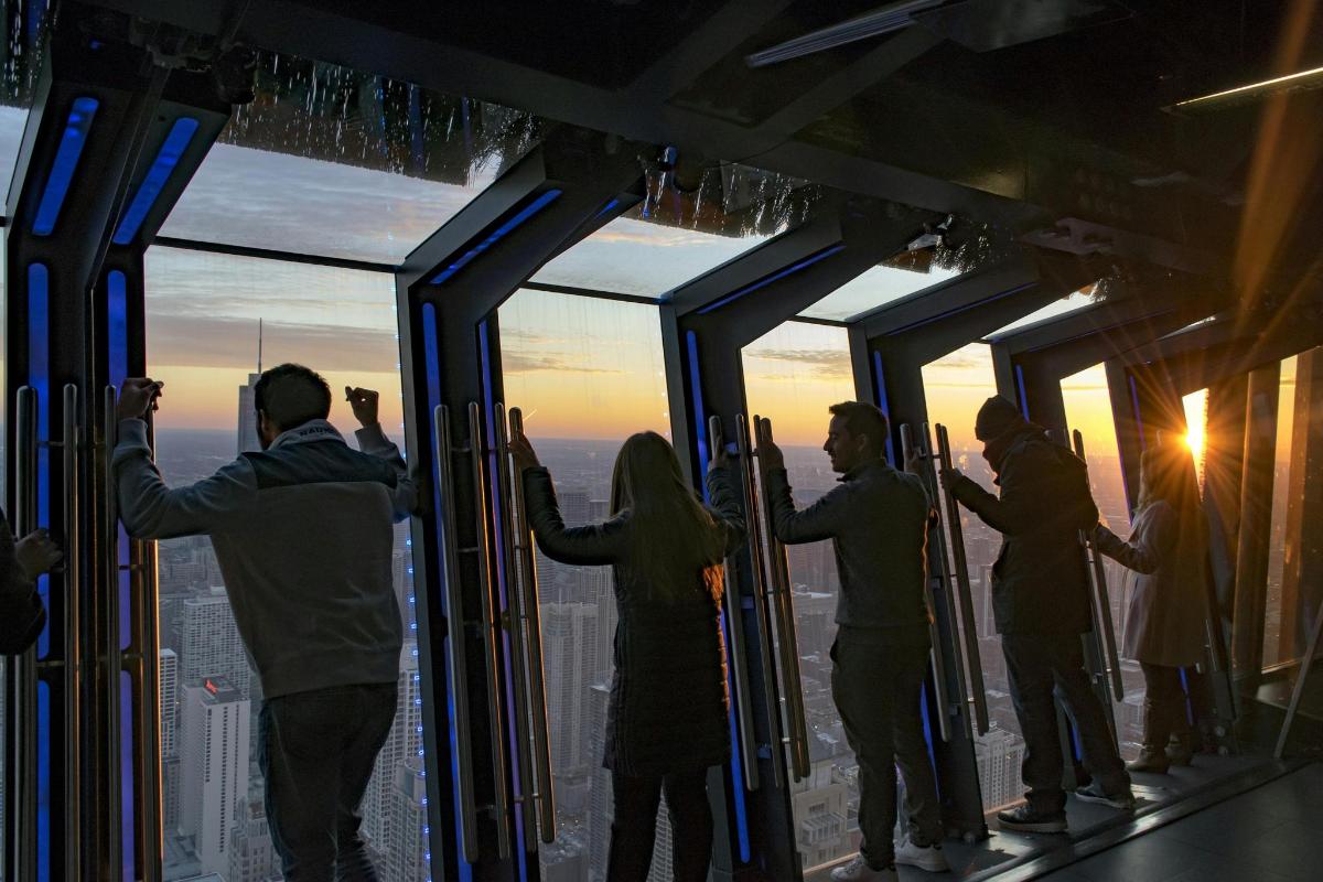 a group of people standing in front of glass windows