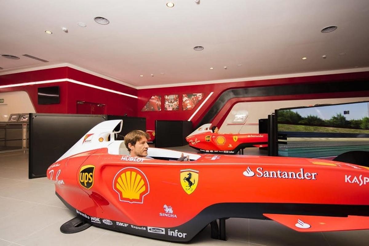 a man sitting in a red race car in a room