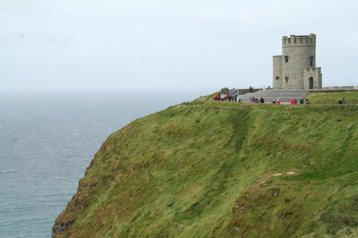 un castillo en la cima de una colina junto al océano