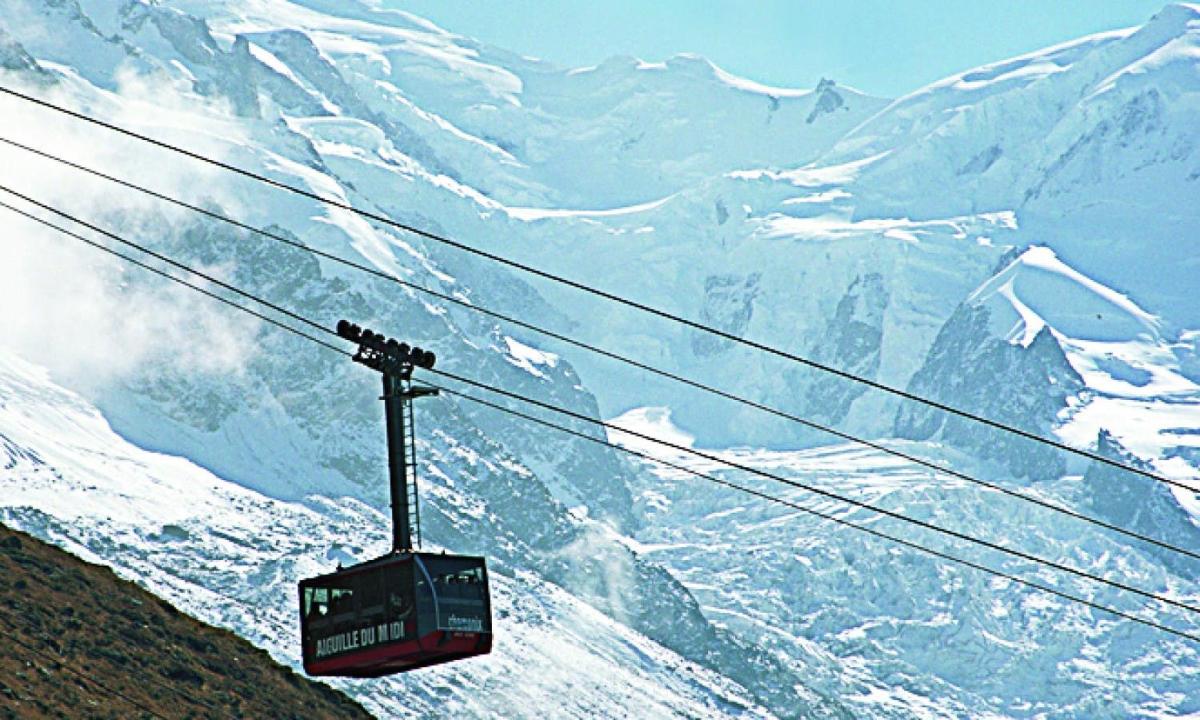 a ski lift in front of a snow covered mountain