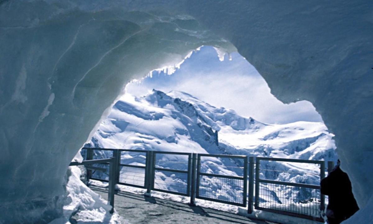 a person standing in front of an ice cave