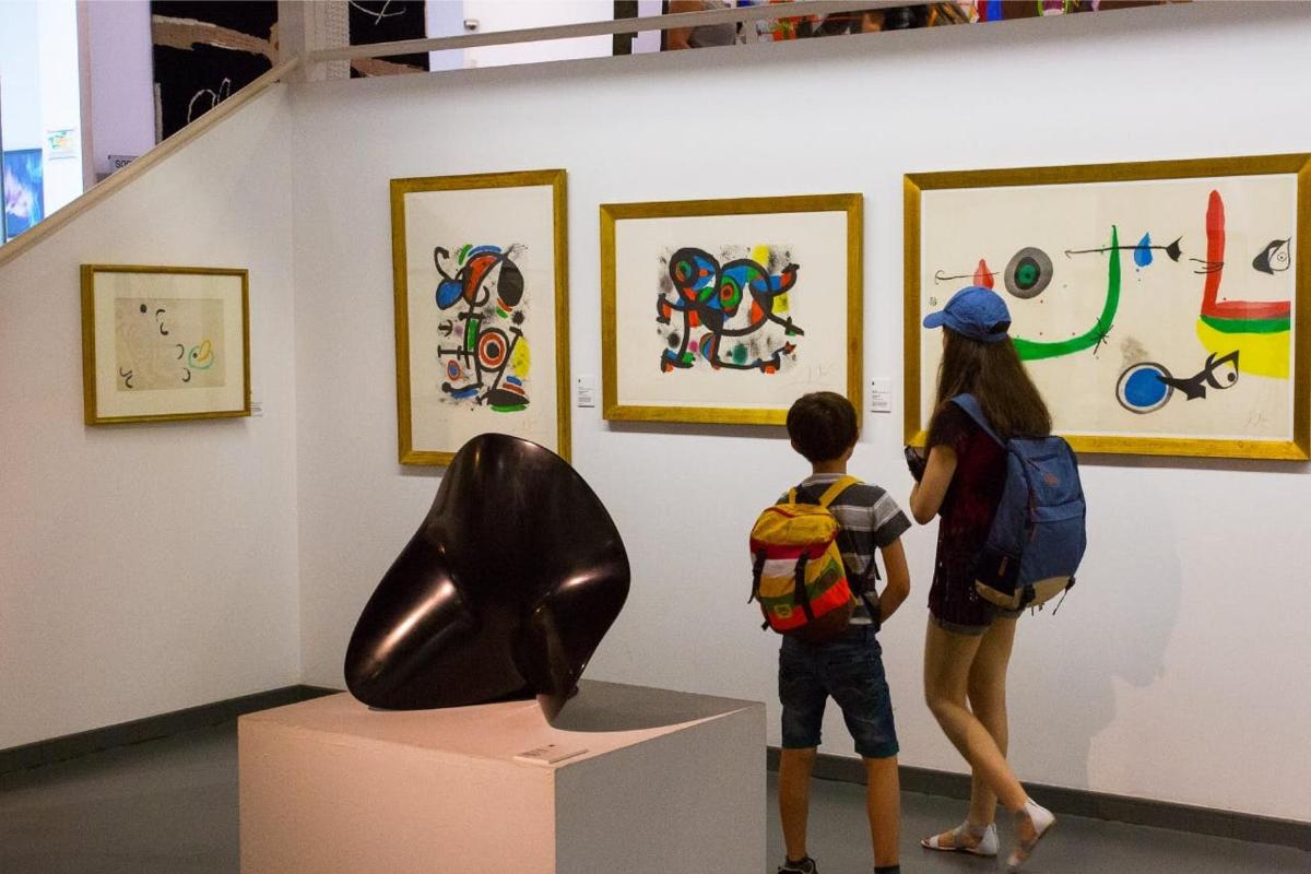 uma mulher e uma criança olhando para uma arte na parede