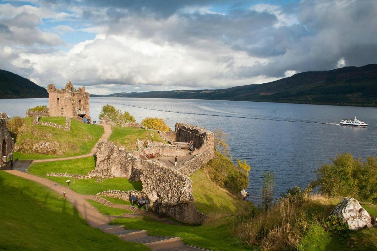 a castle on a hill next to a body of water