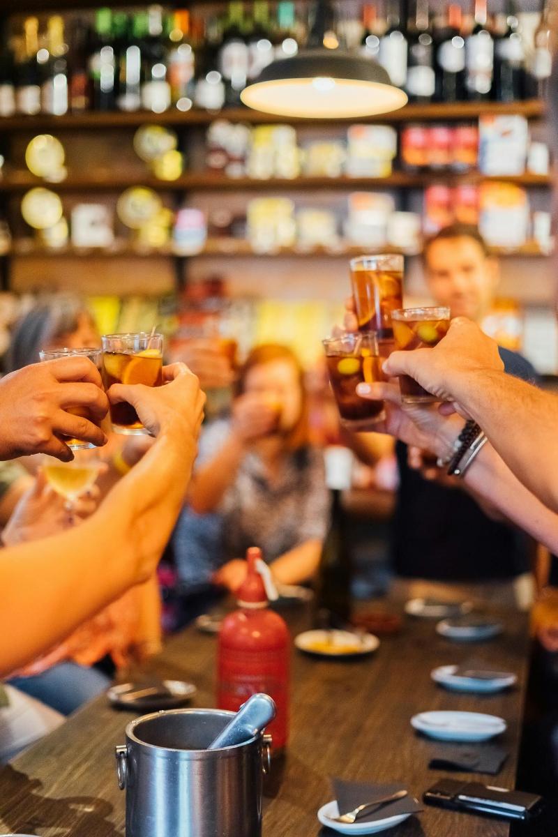 hópur fólks sem heldur á glösum á bar