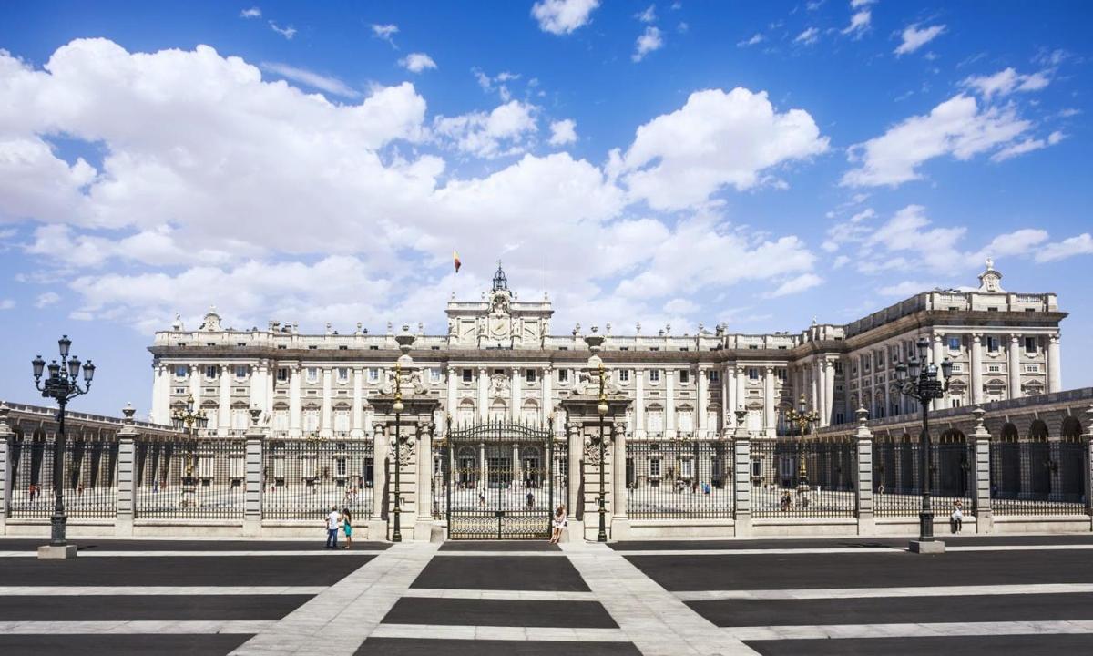 um grande edifício branco com um céu azul com nuvens