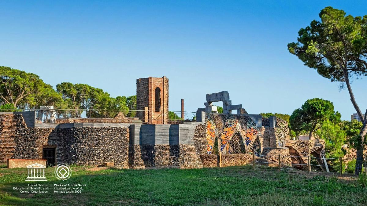 Un edificio de piedra con una torre de reloj en un campo.