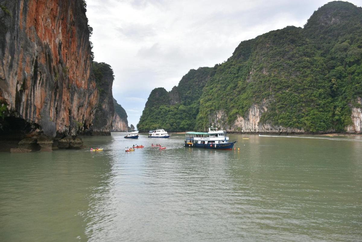 a group of boats in the water near mountains
