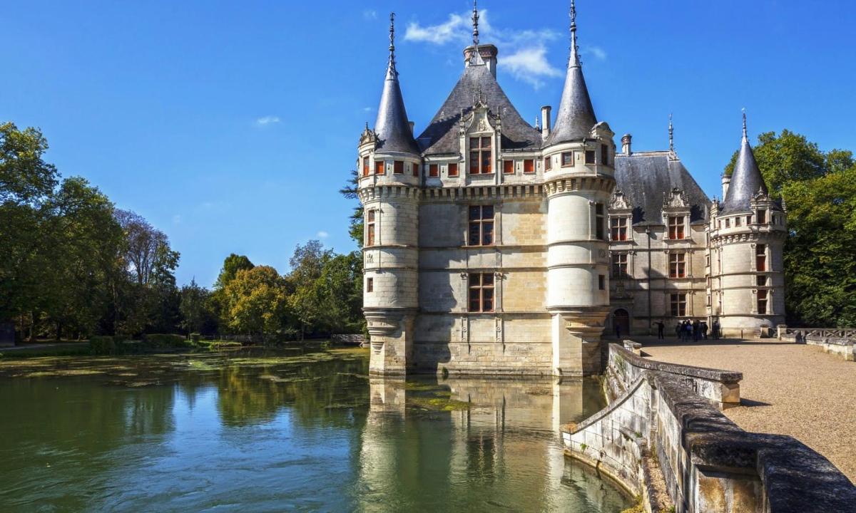 an old castle sitting on the water of a river