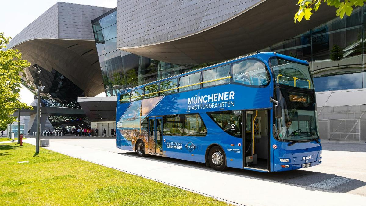 modrý dvoupatrový autobus zaparkovaný před budovou