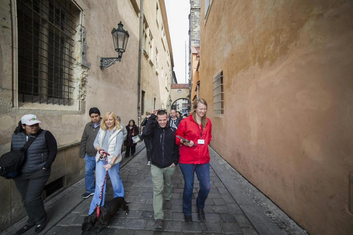 skupina lidí jdoucích úzkou uličkou