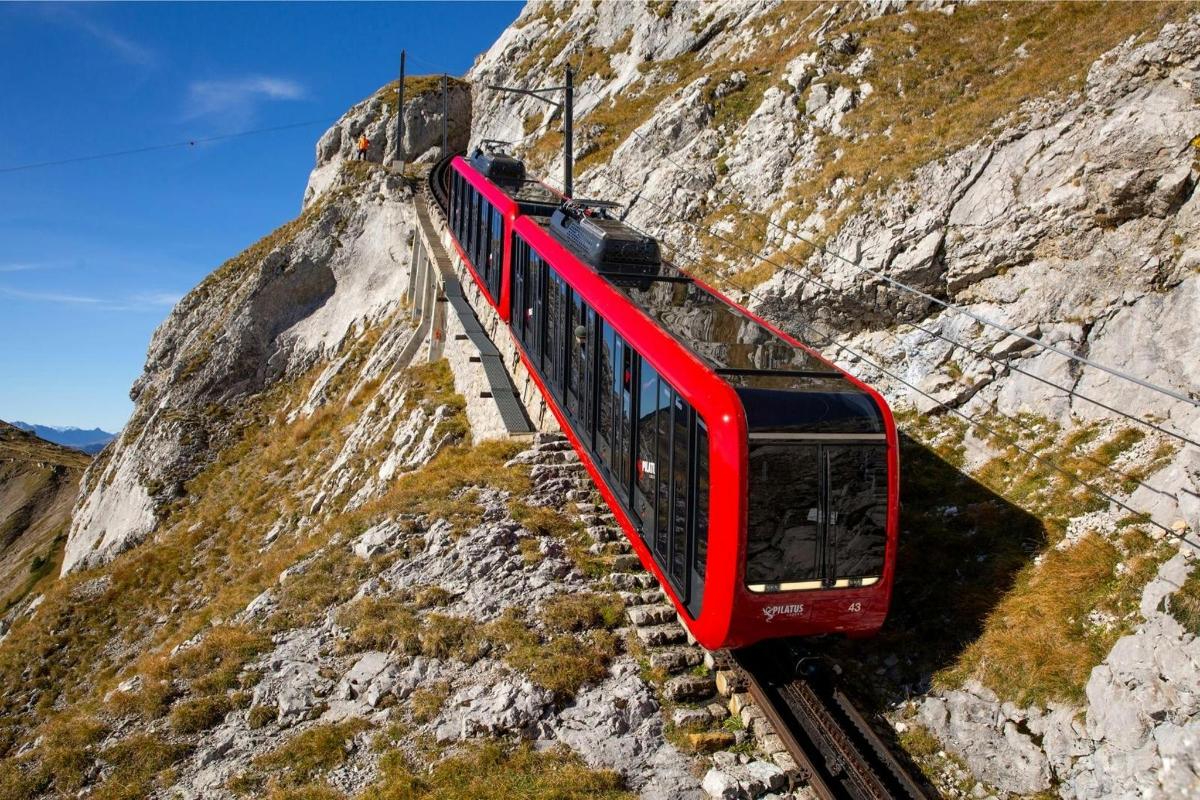 a red train on the tracks on a mountain