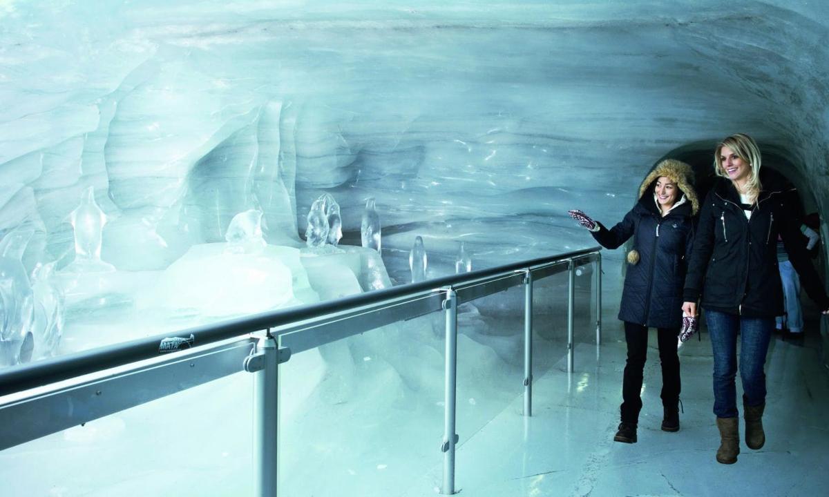 two women standing in front of an ice cave