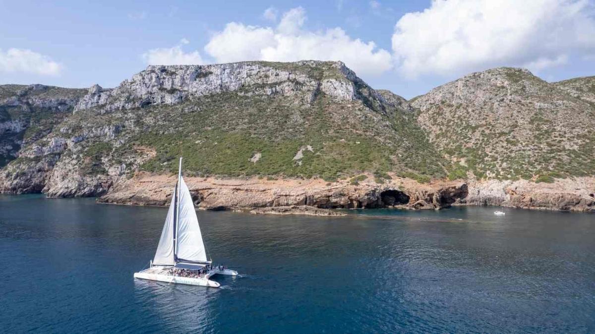 ein Segelboot im Wasser in der Nähe eines Berges