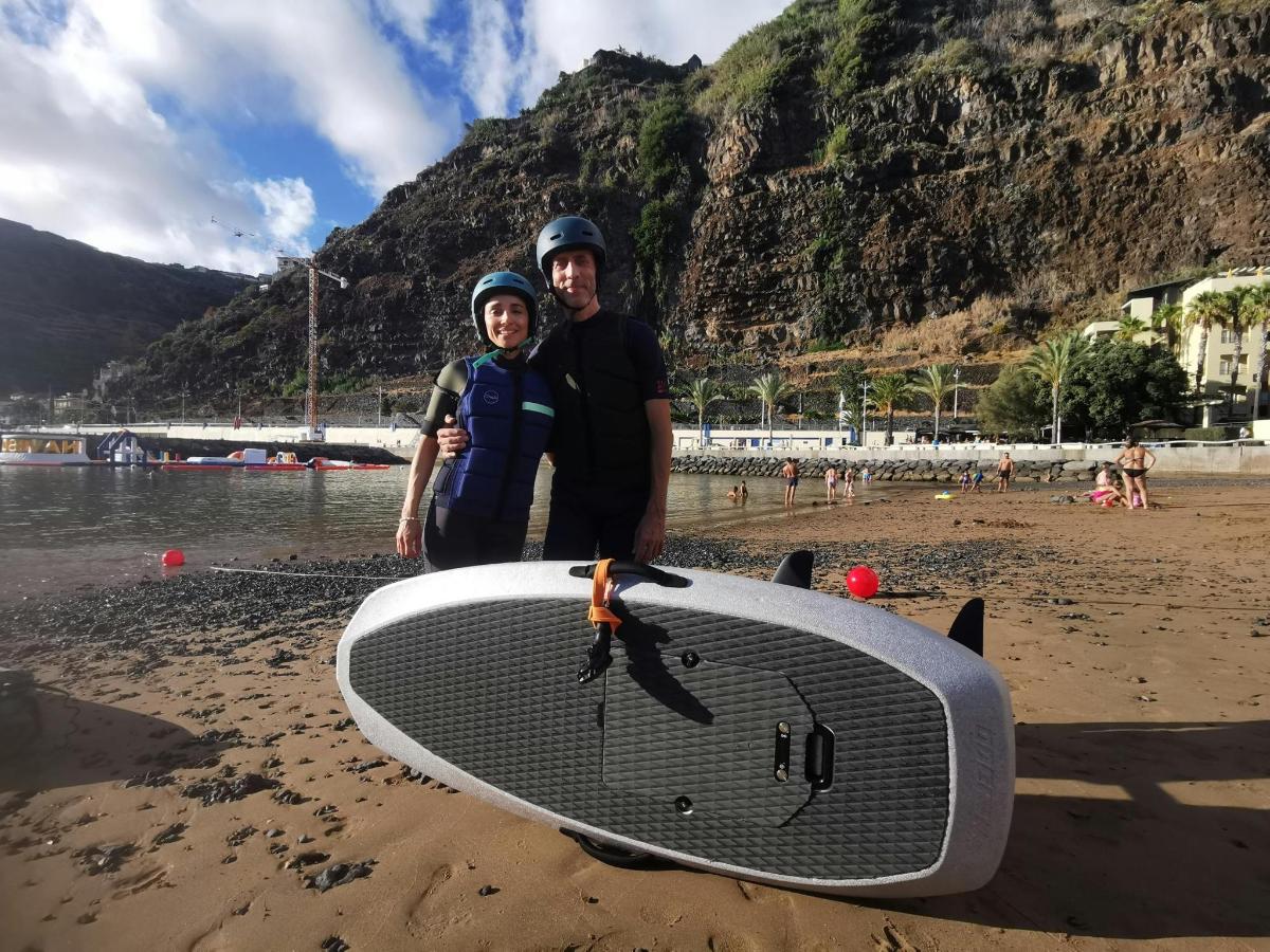 mężczyzna i chłopiec stojący na plaży z deską surfingową