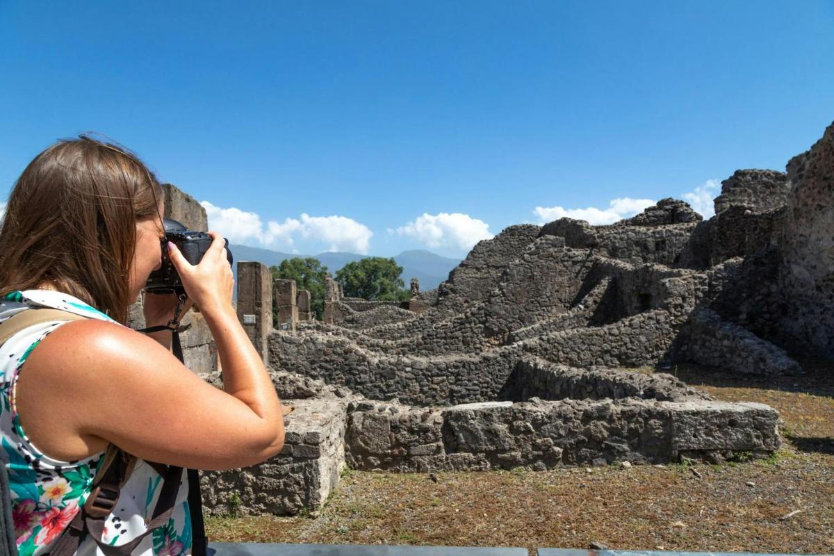 a woman taking a picture of an ancient ruins