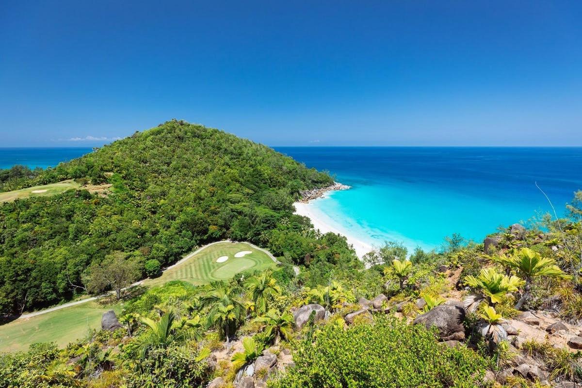 a golf course on a hill next to the ocean