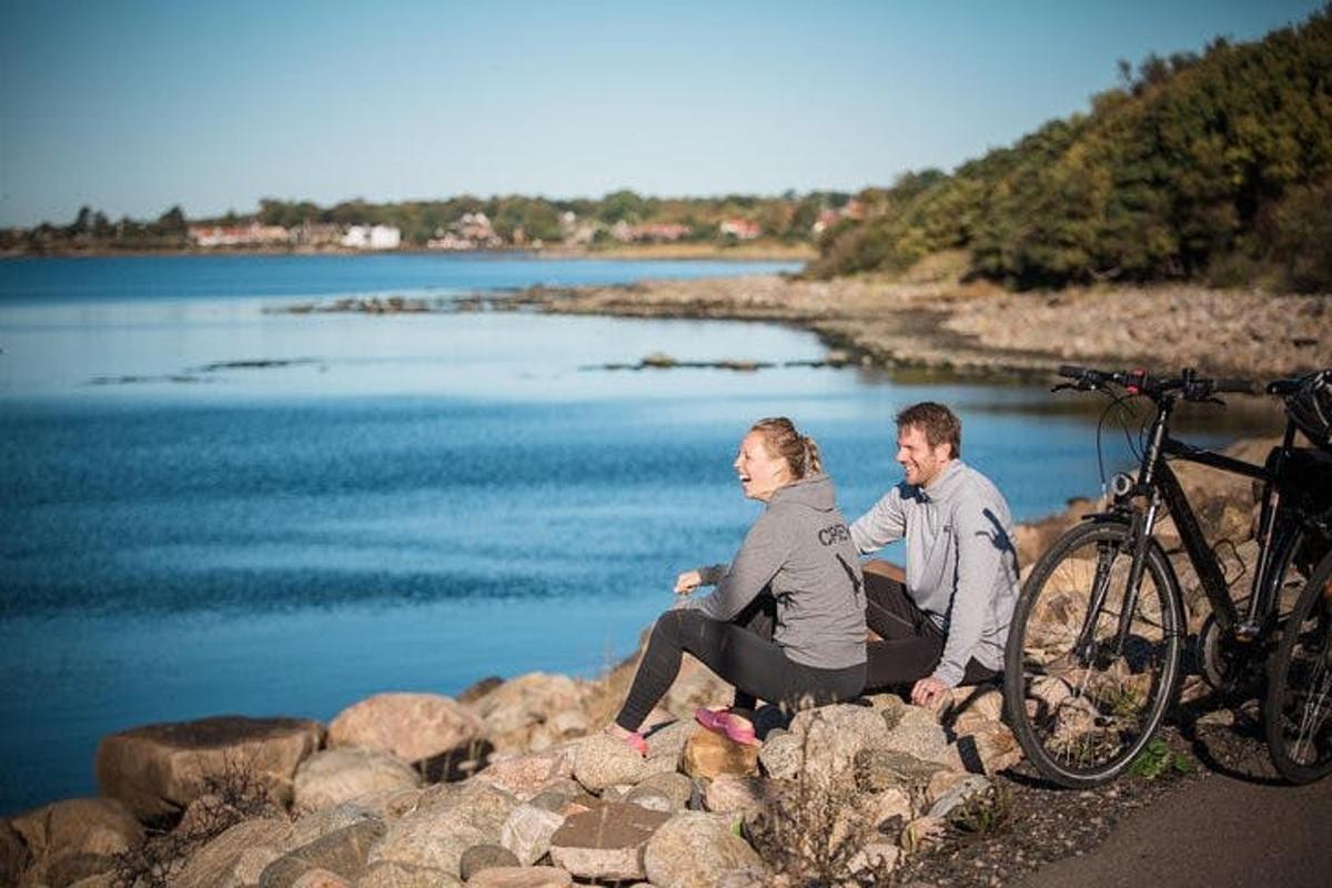en mann og en kvinne som sitter på steiner ved siden av en sykkel