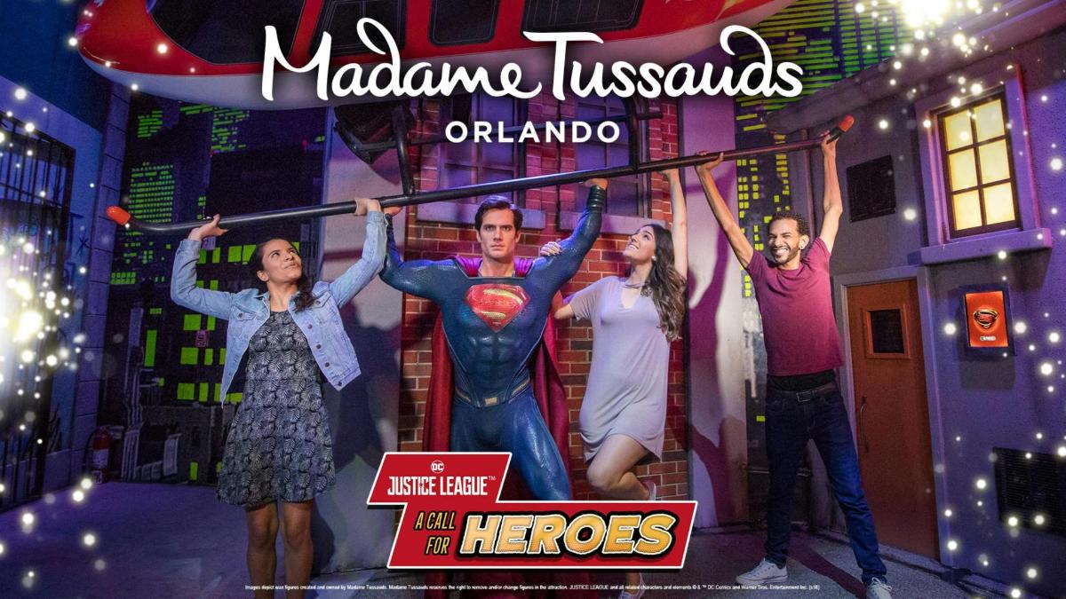 a group of people on a stage with a superhero sign