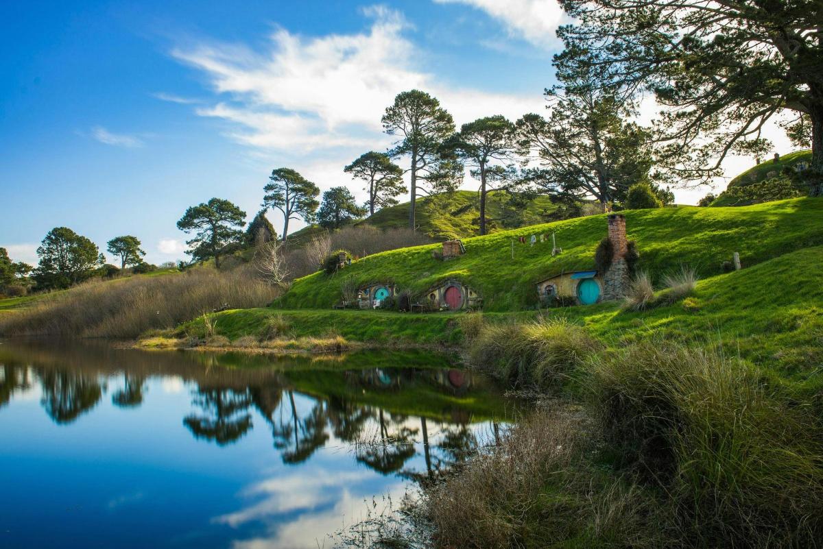 a grassy hill with a lake in the foreground