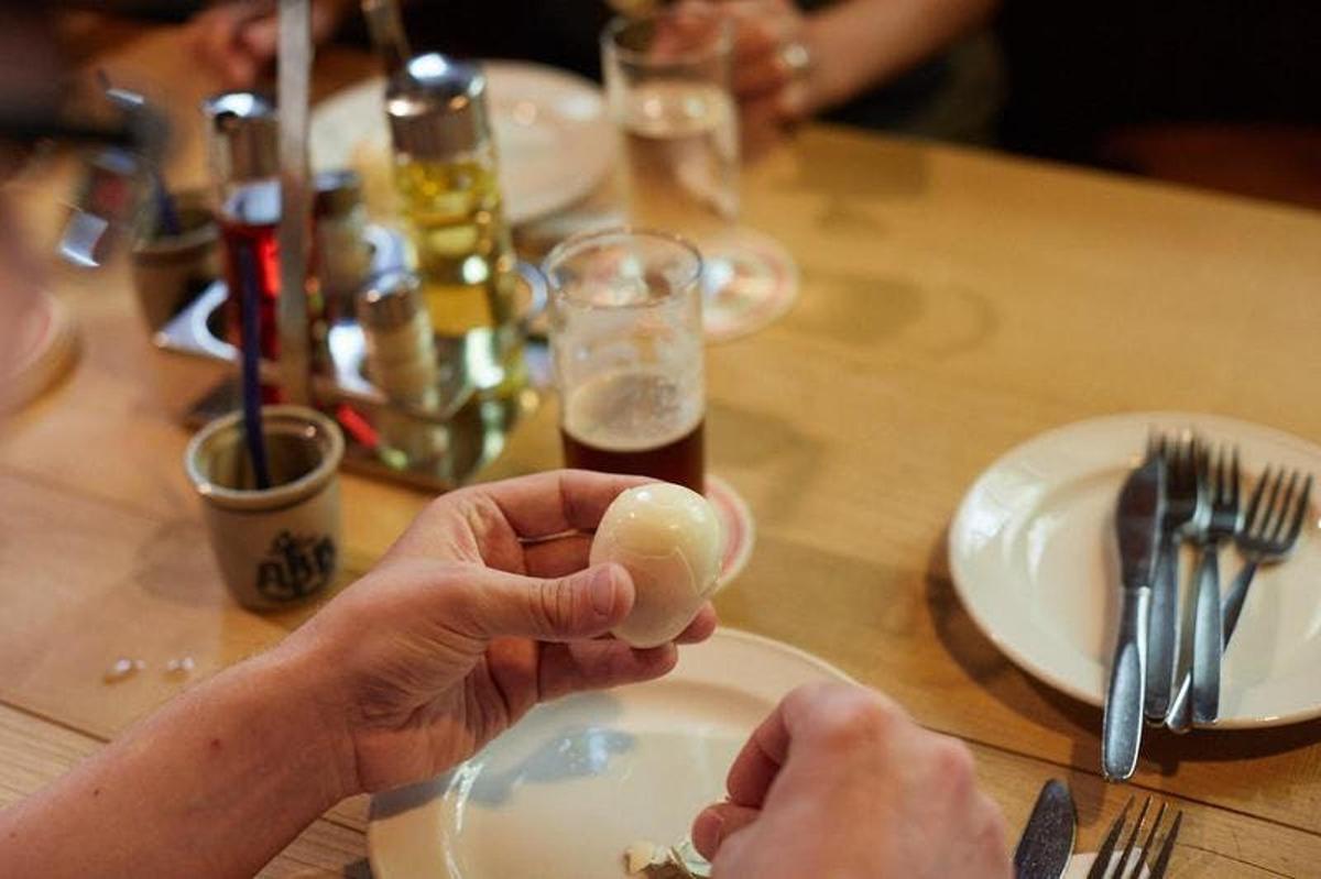 en person som holder et stykke mat på et bord