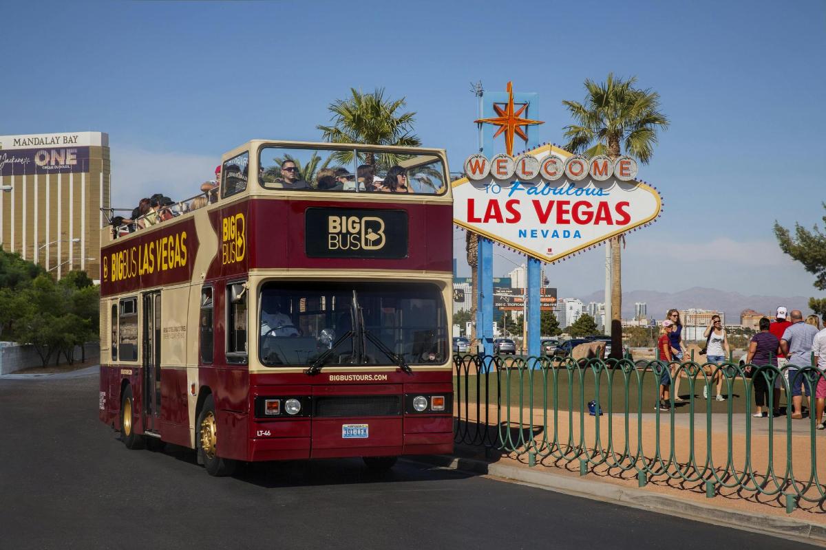 divstāvu autobuss brauc garām Lasvegasas zīmei