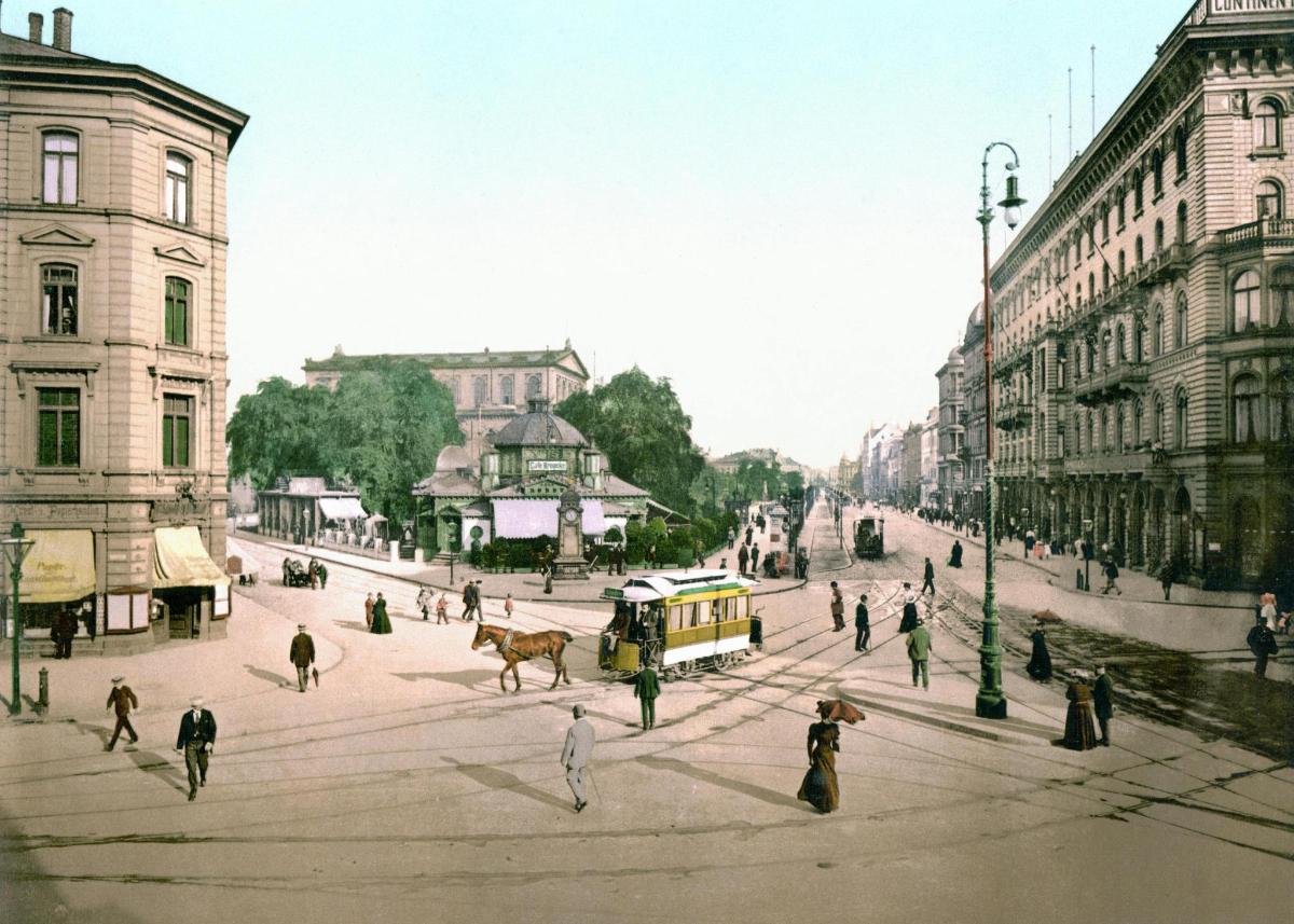 an old photo of a city street with people and a tram