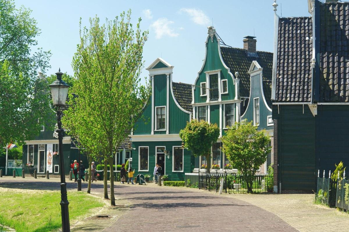 uma grande casa verde e branca com um poste de luz