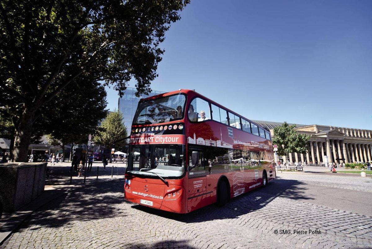 a red double decker bus driving down a street