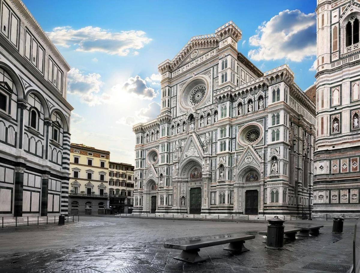 un grande edificio con una panchina di fronte