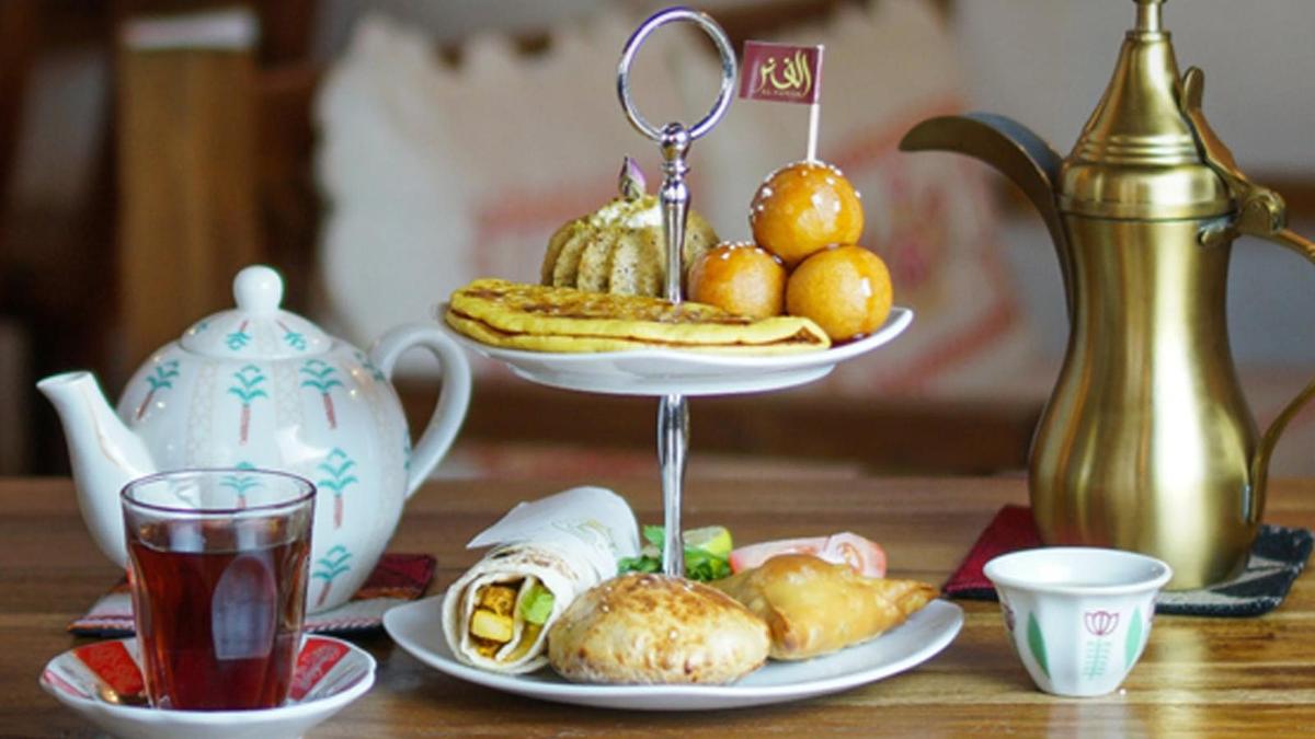 a table with a plate of food and a tea pot