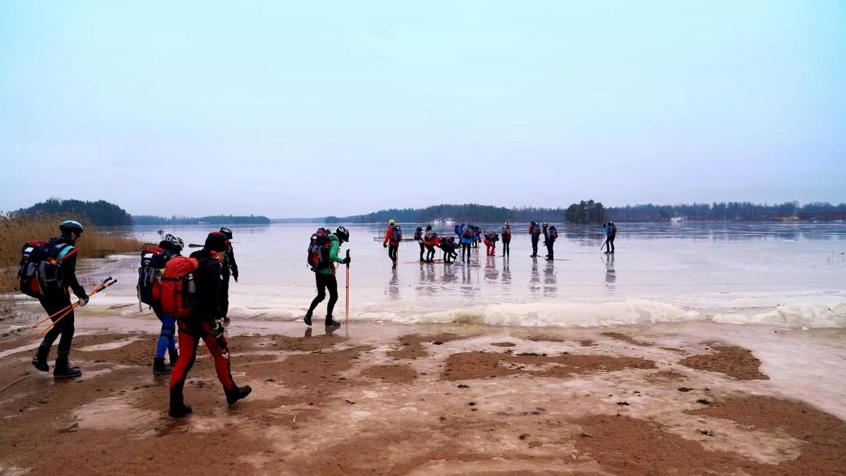eine Gruppe von Menschen, die am Strand spazieren gehen
