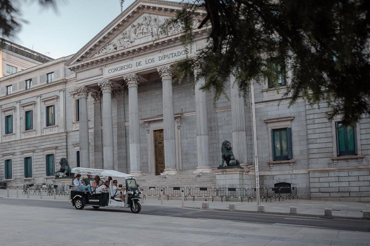 a group of people riding in a car in front of a building
