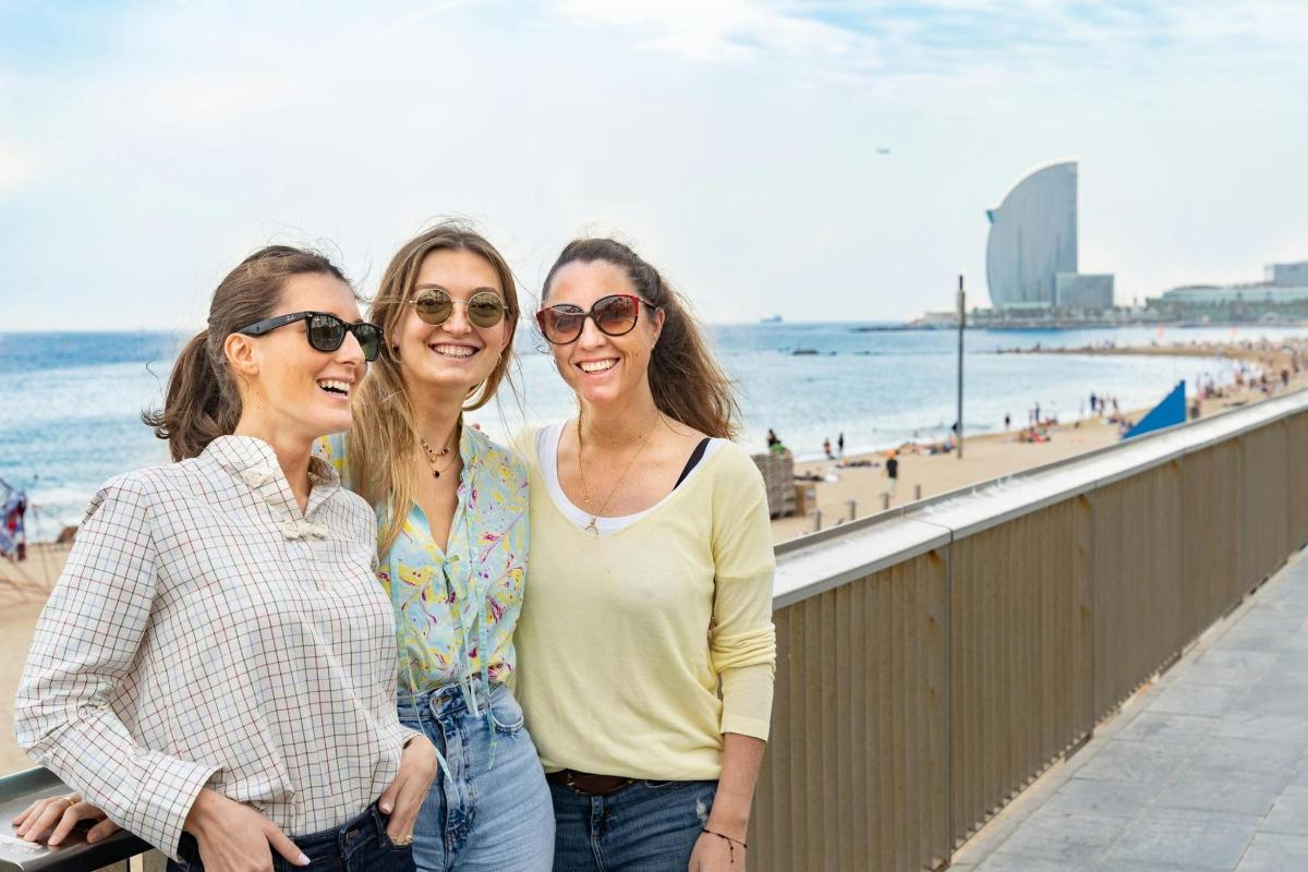 tre donne sono in piedi accanto alla spiaggia