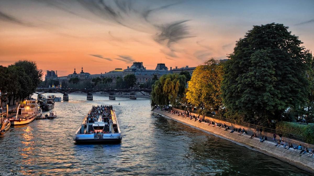 a group of boats on a river at sunset