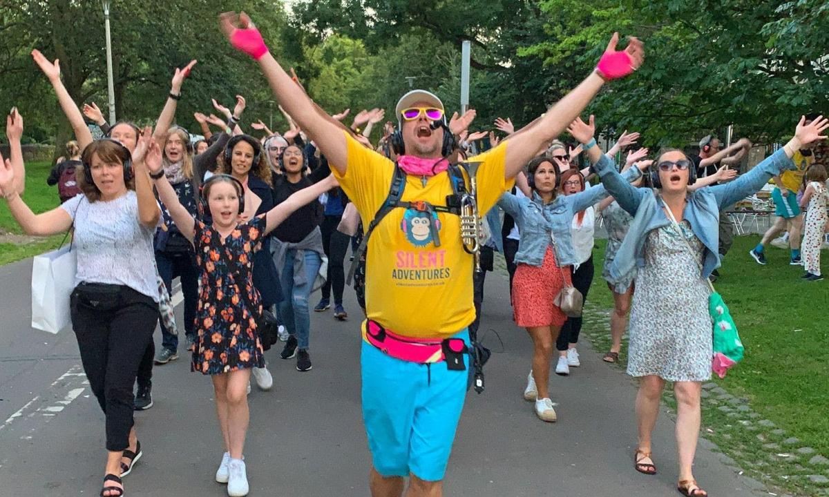 egy csoport ember sétál az utcán, felemelt kézzel