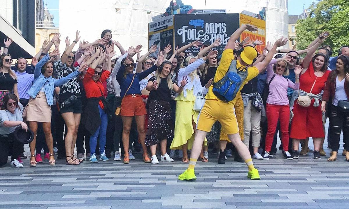 egy tömeg, amely egy utcán táncoló férfit néz