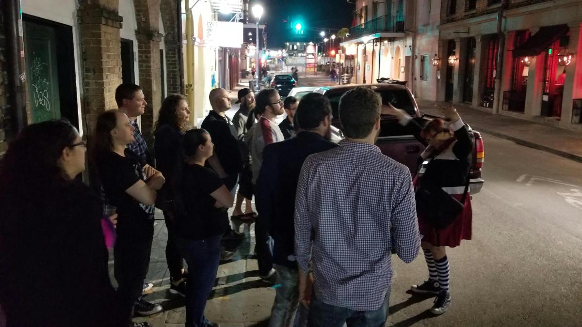 skupina lidí stojících v noci na ulici