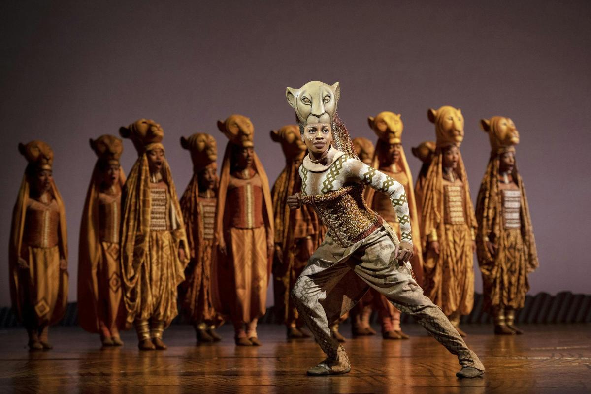 a man standing in front of a group of dancers