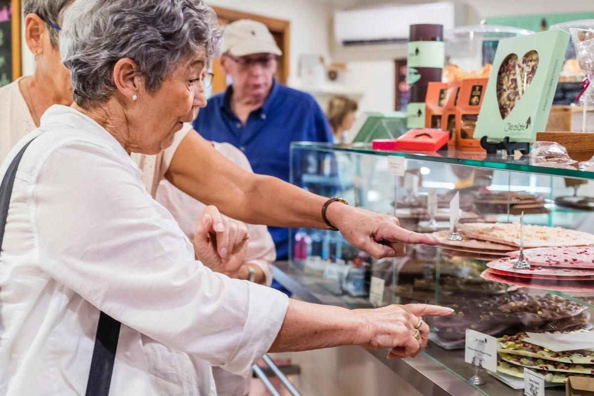 an older woman buying food in a bakery