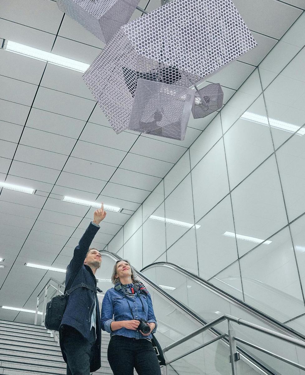 muž a žena stojaci na eskalátore