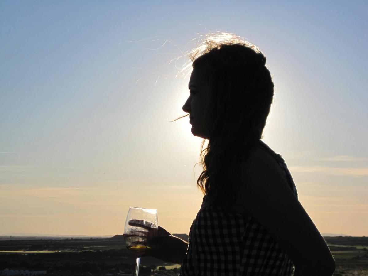 a woman is holding a glass of wine