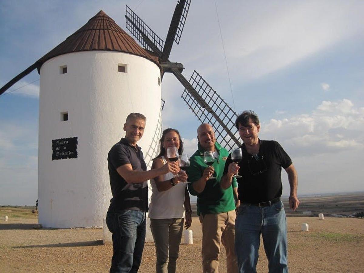 isang grupo ng mga tao na nakatayo sa harap ng windmill