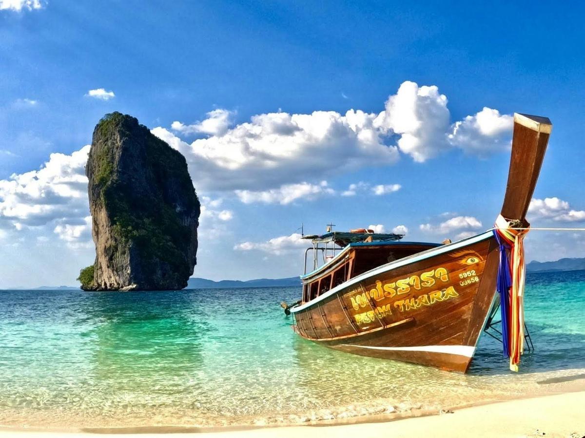 a boat on the beach with a rock in the water