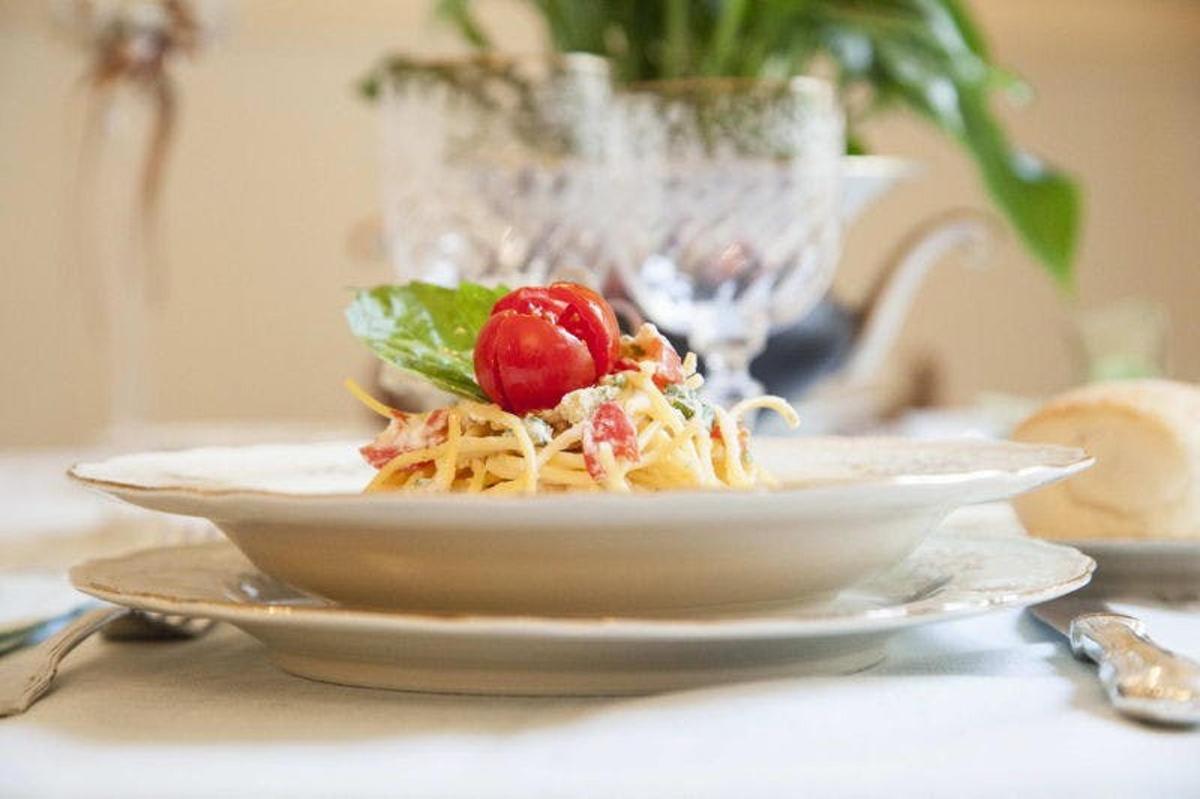 un piatto di pasta con una ciliegia su un tavolo