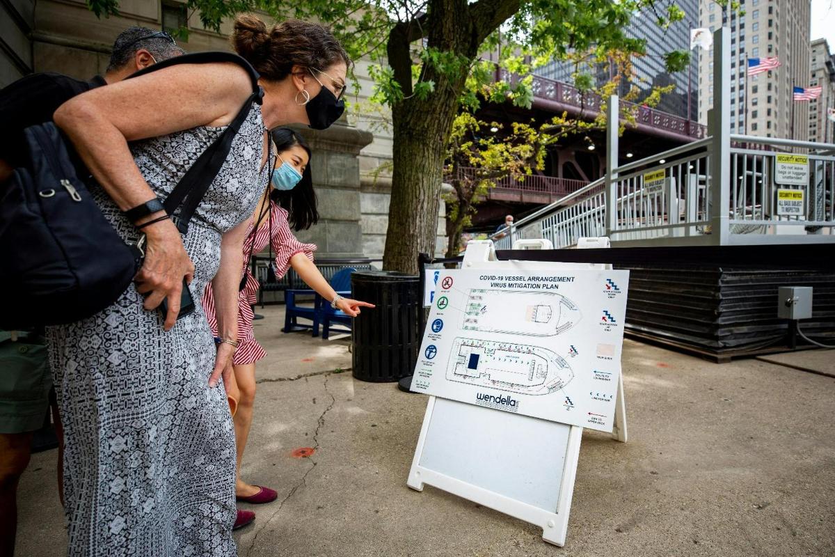 a woman standing next to a sign on the sidewalk
