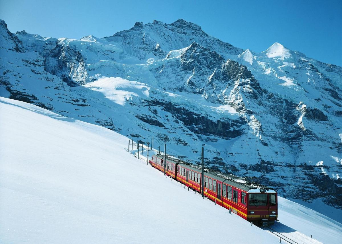 a red train traveling down a snow covered mountain