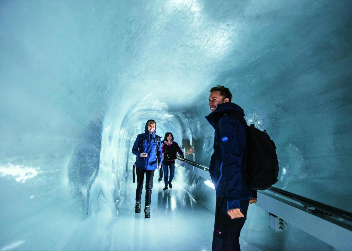 a group of people walking through an ice cave