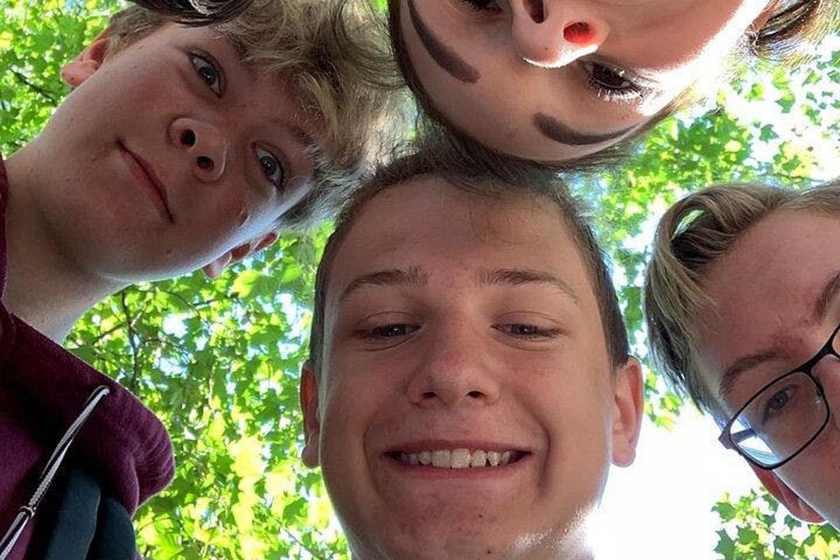 un gruppo di bambini in piedi attorno alla testa di un uomo